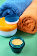 still-life cosmetic cream and towels on a green still-life cosmetic cream and towels on a green