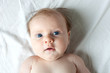 A young baby looks a bit astonished into the camera