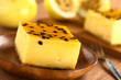 Fresh passion fruit cheesecake dessert on wooden plate