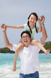 asian father with little girl running on the beach