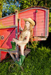 young woman standing by old threshing machine