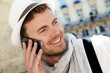 Smiling trendy guy talking on the phone in town Smiling trendy guy talking on the phone in town