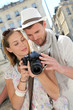 Couple enjoying taking pictures while visiting city