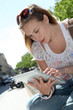 Blond woman in town using electronic tablet Blond woman in town using electronic tablet