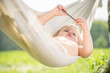 Adorable baby relax in hammock with small stick