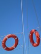 Orange lifebuoys opposite a blue sky Orange lifebuoys opposite a blue sky
