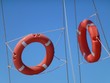 Orange lifebuoys opposite a blue sky Orange lifebuoys opposite a blue sky