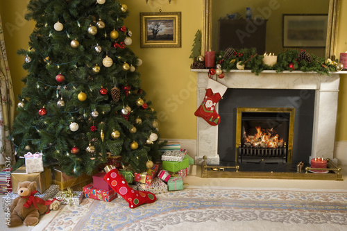 Photo: Christmas tree and gifts by fireplace Christmas tree and gifts by fireplace