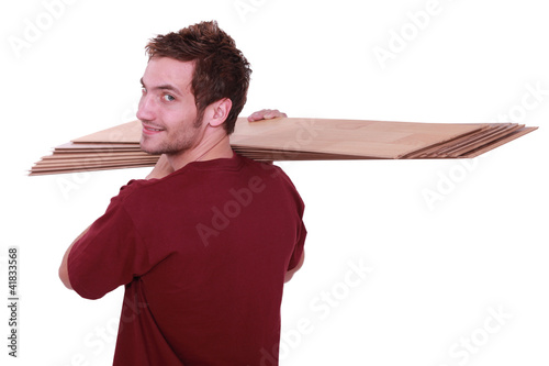 Photo: Man carrying parquet slats Man carrying parquet slats