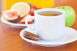 cup of tea,cookie,apple, lemon, fig and strawberries on a plate