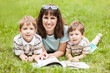 Mother and sons reading book outdoor