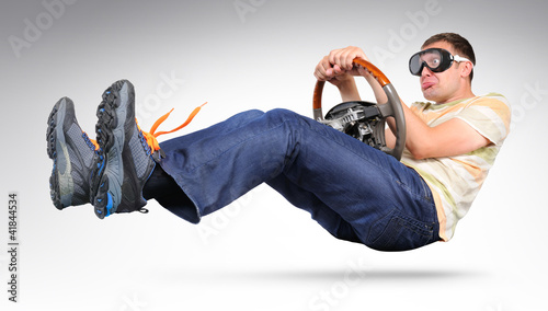Photo: Funny driver in goggles with a wheel, auto concept Funny driver in goggles with a wheel, auto concept