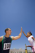 Photo: Male athlete giving girl (3-5) high five, low angle view Male athlete giving girl (3-5) high five, low angle view