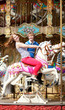 Cheerful young couple enjyong their ride on merry-go-round