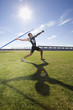 Photo: Male athlete preparing to throw javelin, low angle view (lens flare) Male athlete preparing to throw javelin, low angle view (lens flare)