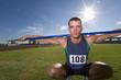 Photo: Male athlete crouching with javelin over shoulders, portrait (lens flare) Male athlete crouching with javelin over shoulders, portrait (lens flare)