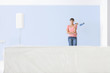 Woman standing in front of painted wall holding paint roller