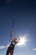 Photo: Male athlete throwing javelin, low angle view (lens flare) Male athlete throwing javelin, low angle view (lens flare)