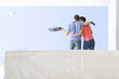 Photo: Couple with paint roller and tray kissing and looking at freshly painted living room wall Couple with paint roller and tray kissing and looking at freshly painted living room wall