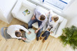 Salesman showing insulation to couple sitting on sofa in living room