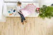Woman on sofa looking at wallpaper sample