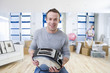 Smiling man holding toaster as woman unpacks in living room