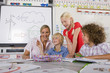 Foto: Curious students and teacher examining model wind turbine in school classroom Curious students and teacher examining model wind turbine in school classroom