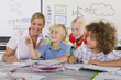 Foto: Curious students and teacher examining model wind turbine in school classroom Curious students and teacher examining model wind turbine in school classroom