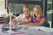 Foto: Teacher helping student study about wind turbines in school classroom Teacher helping student study about wind turbines in school classroom
