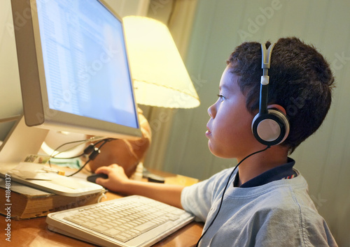 Photo: Little Boy Concentrating at the Home Computer Little Boy Concentrating at the Home Computer