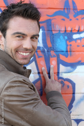 Foto: V for Victory from a man in front of grafitti V for Victory from a man in front of grafitti