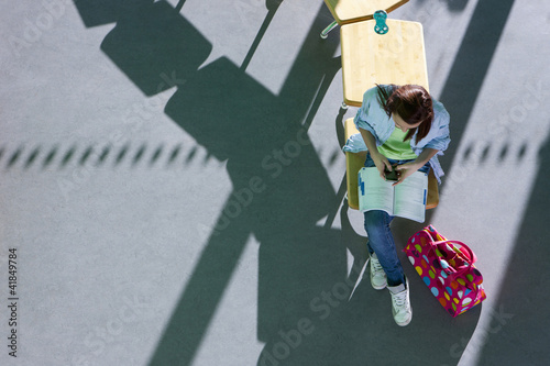 Photo: Student sitting on school desk studying textbook Student sitting on school desk studying textbook