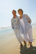 Romantic couple walking barefoot along a beach