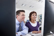 Teacher talking with adult student in college evening class computer lab