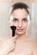 Green eyed model with make-up brush