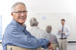Smiling man turning in seat during college evening class