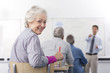 Smiling woman turning in seat during college evening class