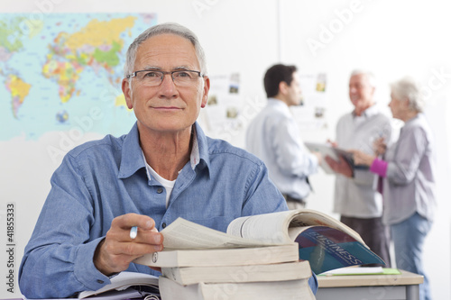 Photo: Adult student studying textbook in college evening class Adult student studying textbook in college evening class
