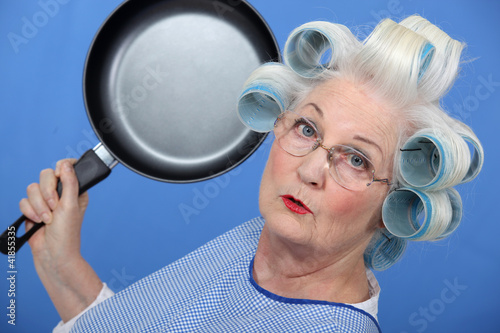 Photo: Elderly lady attacking with frying pan Elderly lady attacking with frying pan
