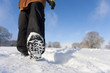 Close up of woman's feet walking through field of snow
