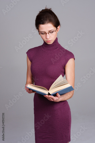 Photo: junge frau mit brille schaut in ein buch junge frau mit brille schaut in ein buch