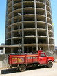 Roter Lastwagen vor dem Gerippe eines Hochhaus Neubaus Roter Lastwagen vor dem Gerippe eines Hochhaus Neubaus