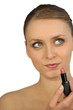 Woman putting on lipstick