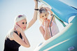 Two blonde girls stand by the broken car Two blonde girls stand by the broken car