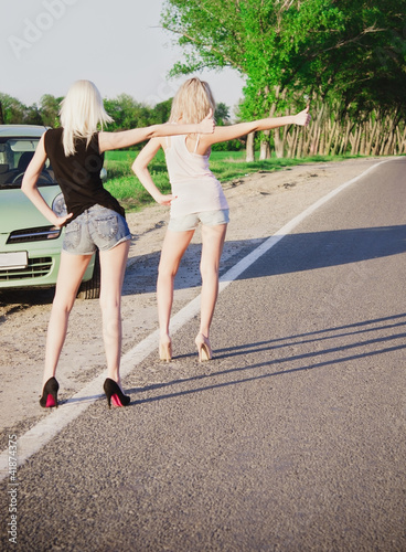 Foto: Two sexy blonde girls standing near broken car and hitchhiking Two sexy blonde girls standing near broken car and hitchhiking