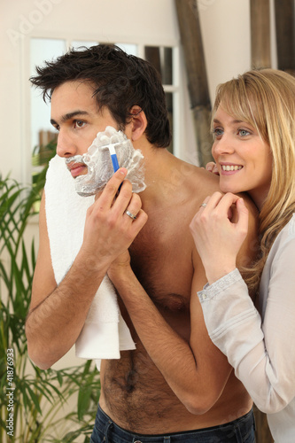 Photo: Young man shaving with his girlfriend watching Young man shaving with his girlfriend watching