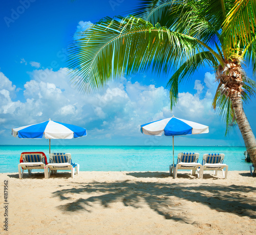 Foto: Vacation and Tourism concept. Sunbeds on the paradise beach Vacation and Tourism concept. Sunbeds on the paradise beach
