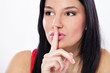 Young woman holding finger on lips Young woman holding finger on lips