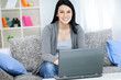 young girl with laptop computer, sitting in living room
