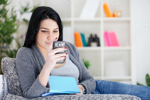 Photo: woman reading message on mobile phone woman reading message on mobile phone